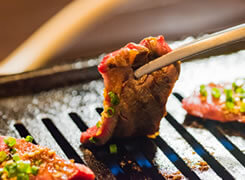 箸でお肉をひっくり返しているイメージ